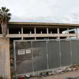 Troviamo lo scheletro di un edificio. Una targhetta informa che per entrare � necessario citofonare, ma in realt� il cancello � aperto e permette di avere accesso in un�area dominata da rifiuti, spazzatura e una palma morta. Era la sede della �Future Gate�, una societ� che costruiva e gestiva slot-machine 